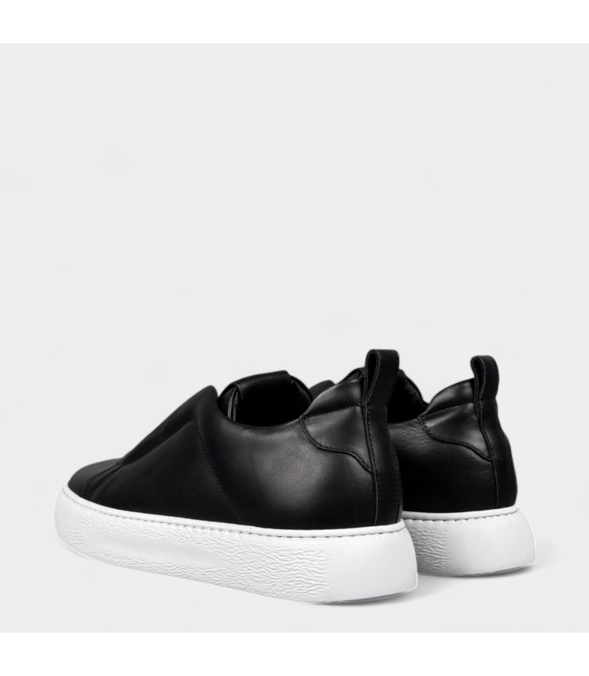 Задній фасад кросівок із видимою підошвою та елементами водо‑захисного покриття.